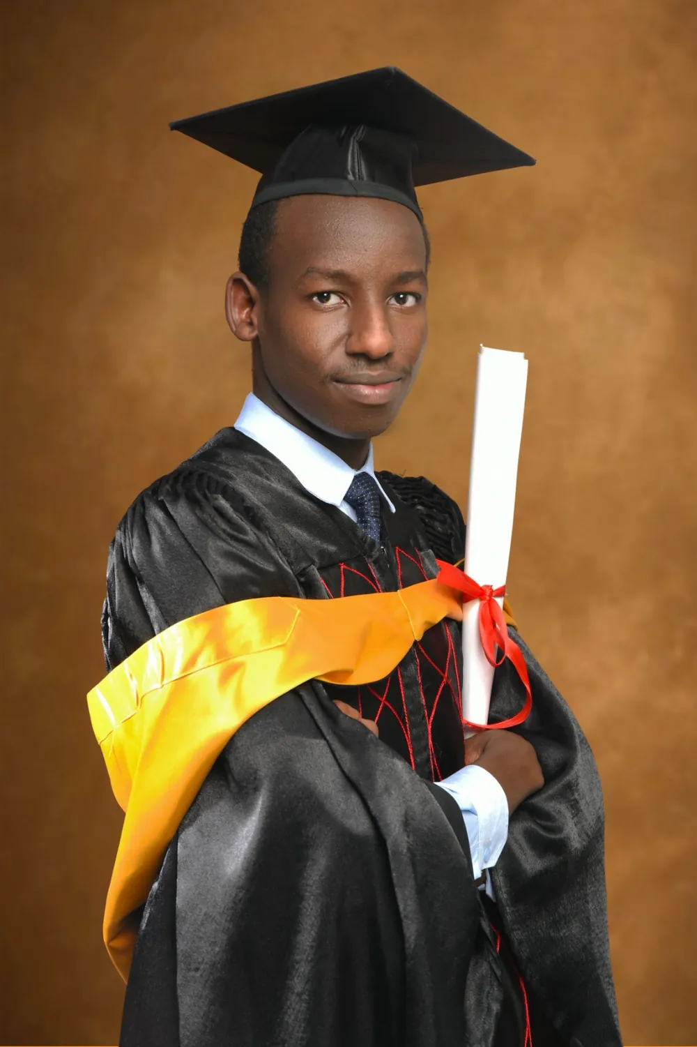 Fidel in his graduation gown, holding his degree